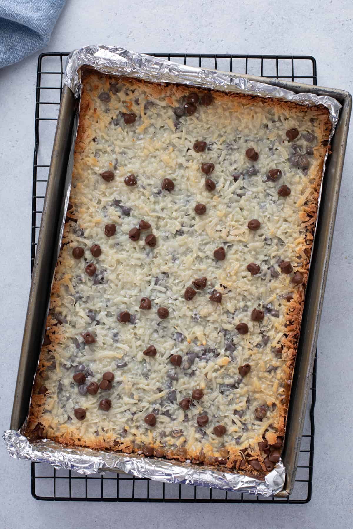 Baked magic bars cooling on a wire rack.