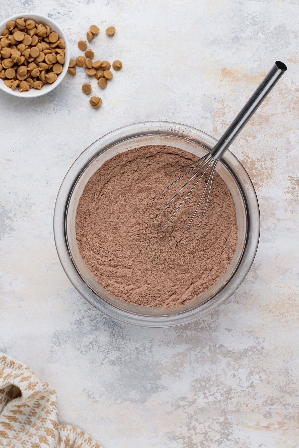 Dry ingredients for chocolate peanut butter cookies whisked in a white bowl.