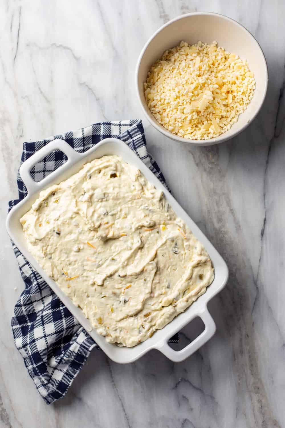 Jalapeno popper dip spread into a white baking dish