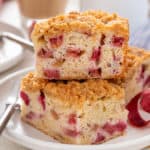 Slices of rhubarb cake stacked on a white plate.