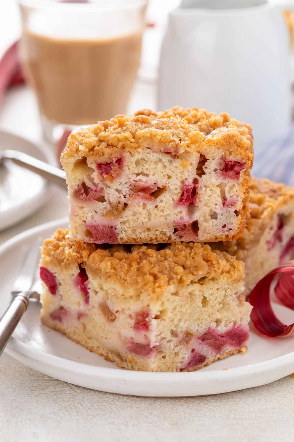 Two slices of rhubarb cake stacked on a white plate.