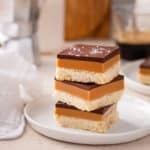 Millionaire shortbread stacked on a white plate.
