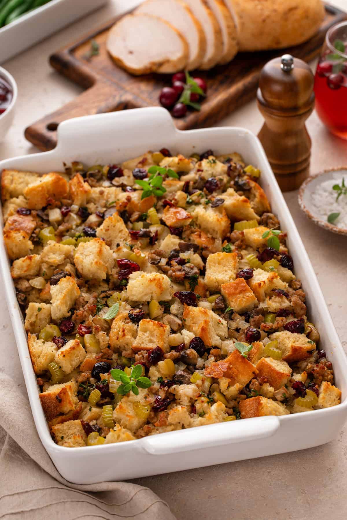 Baked pan of sausage and cranberry stuffing on a countertop.
