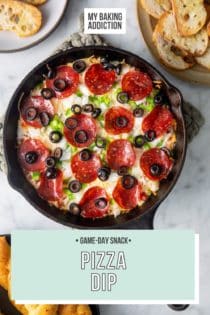 Baked pizza dip in a cast iron skillet, surrounded by bowls of crostini and breadsticks. Text overlay includes recipe name.