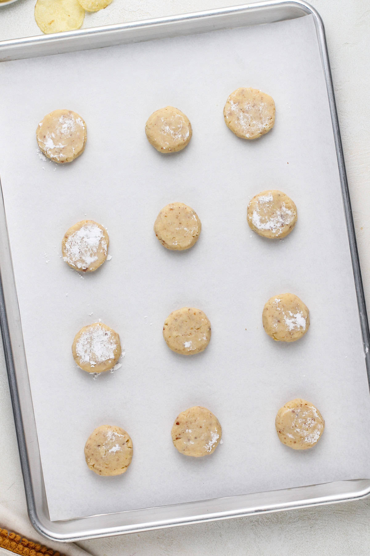 Pressed potato chip cookie dough on a baking sheet, ready to go in the oven.