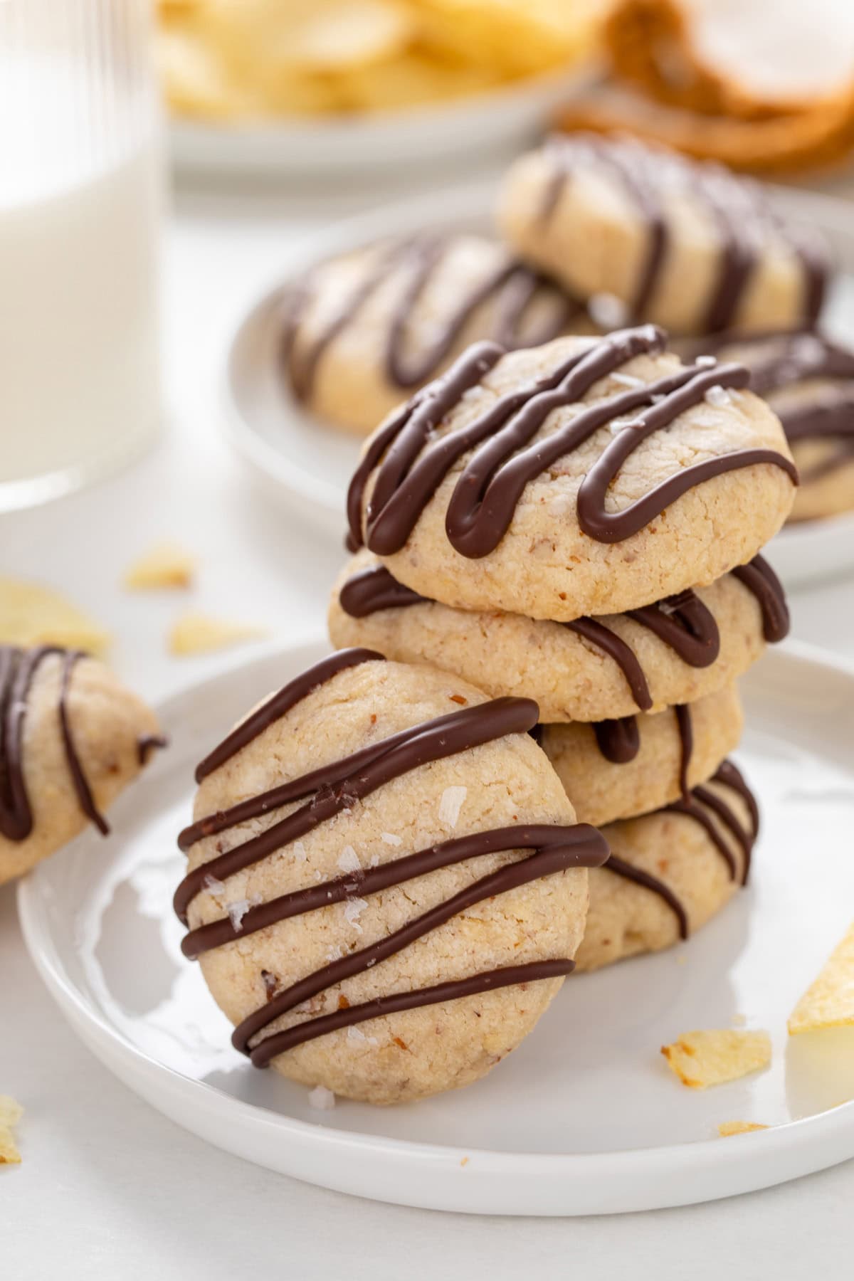 Several potato chip cookies stacked on a white plate.