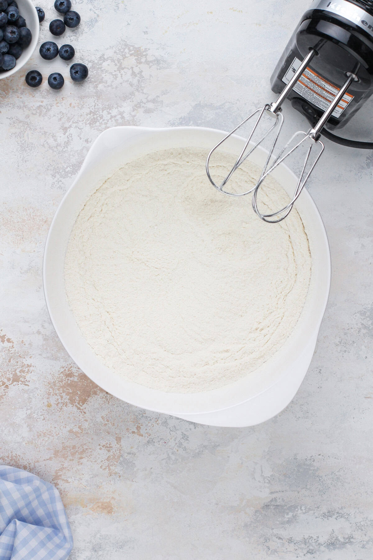 Dry ingredients for blueberry cupcakes mixed in a white bowl.