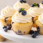 Blueberry cupcakes on a white cake plate.