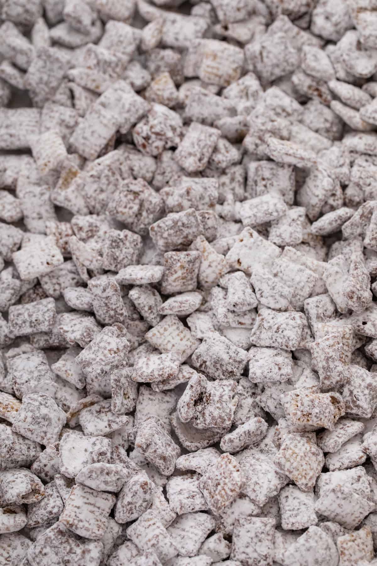 Close up of puppy chow spread onto a baking sheet.