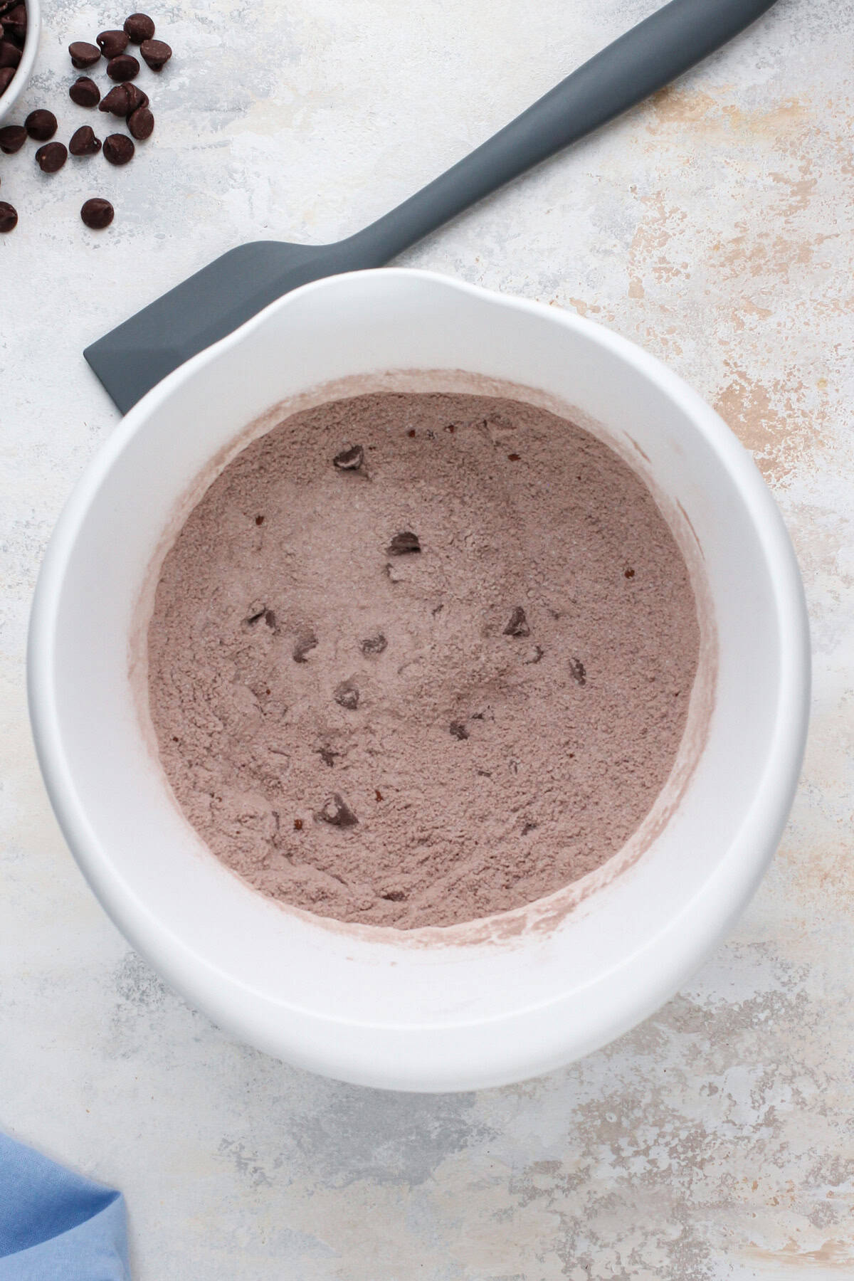 Dry ingredients for double chocolate muffins combined in a white bowl.