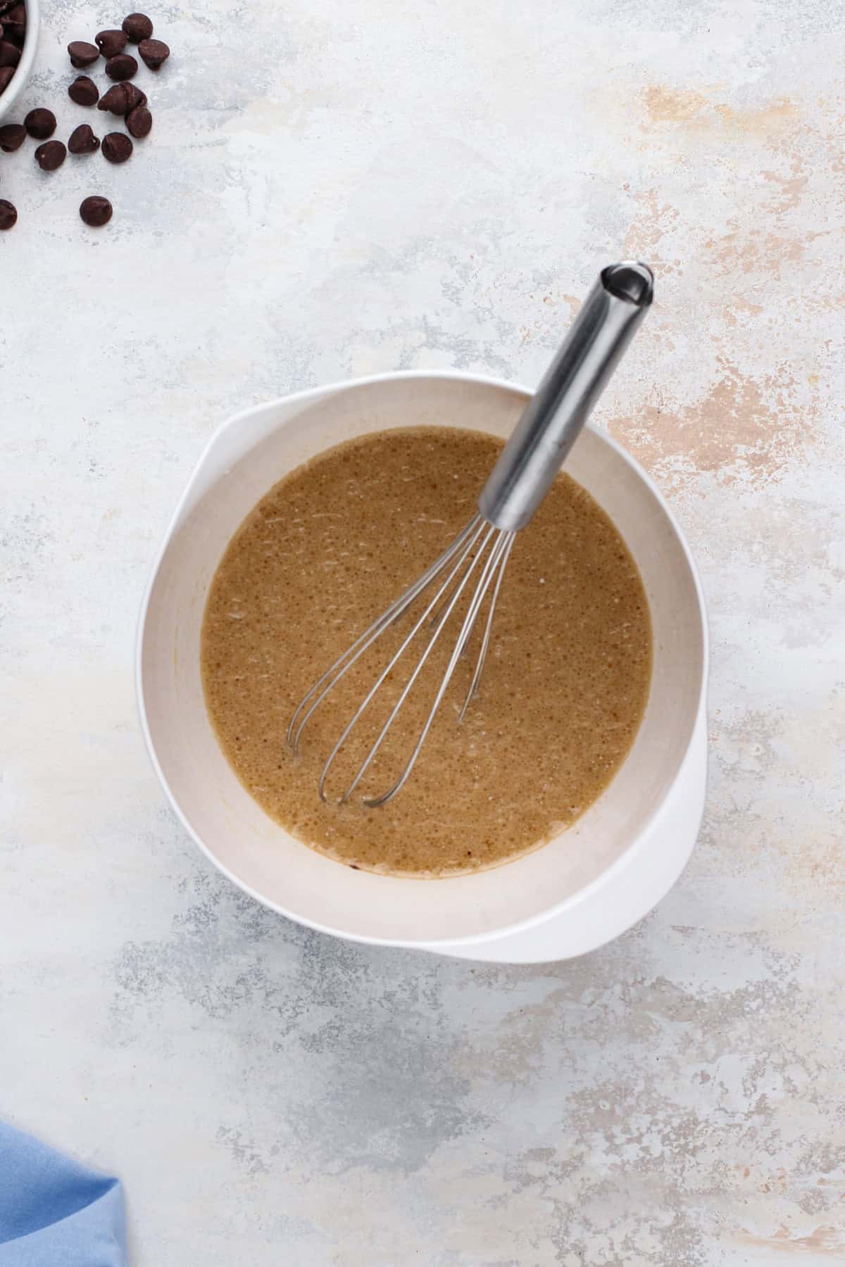 Wet ingredients for double chocolate muffins whisked in a white bowl.