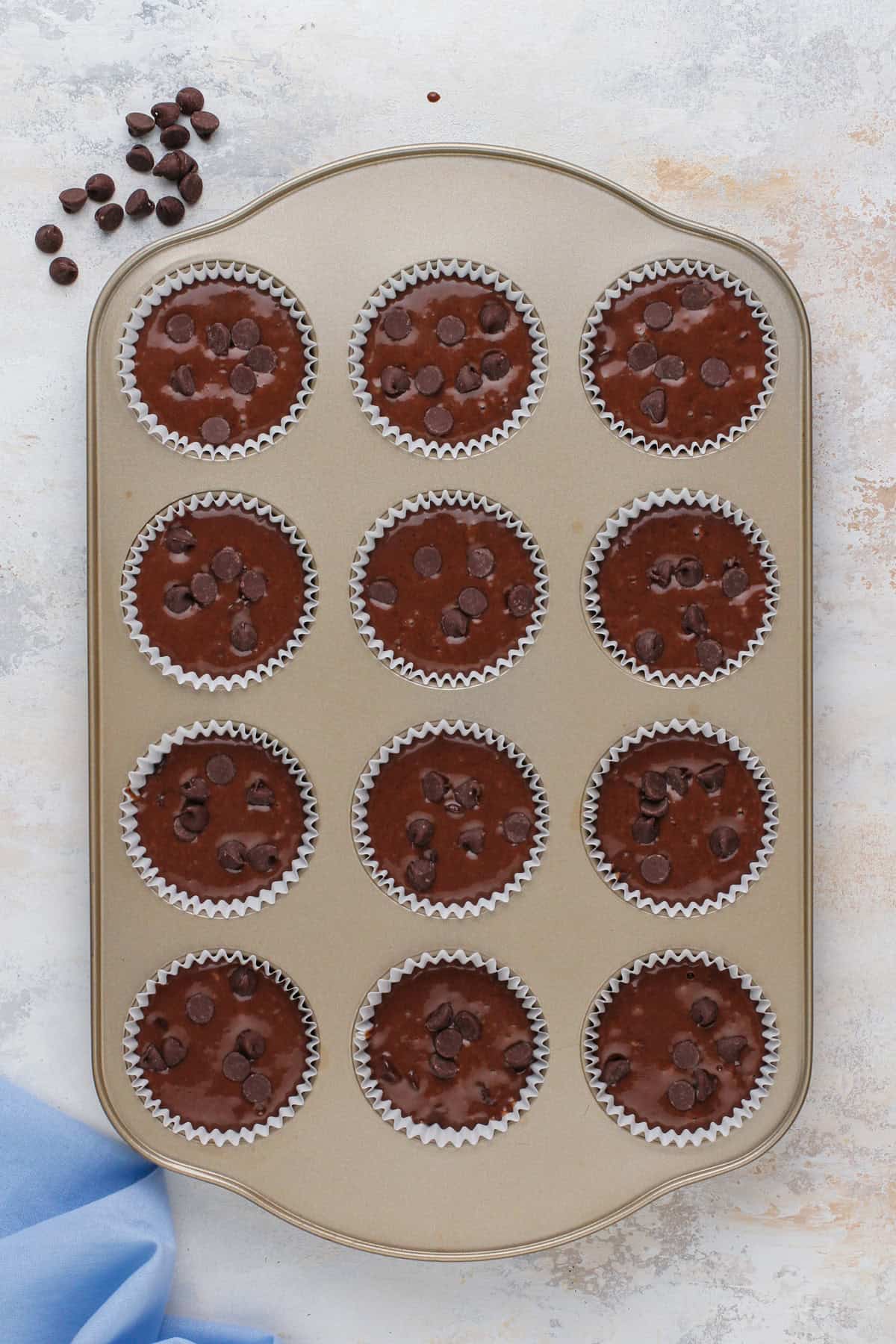Unbaked double chocolate muffins in a muffin tin, ready to go in the oven.