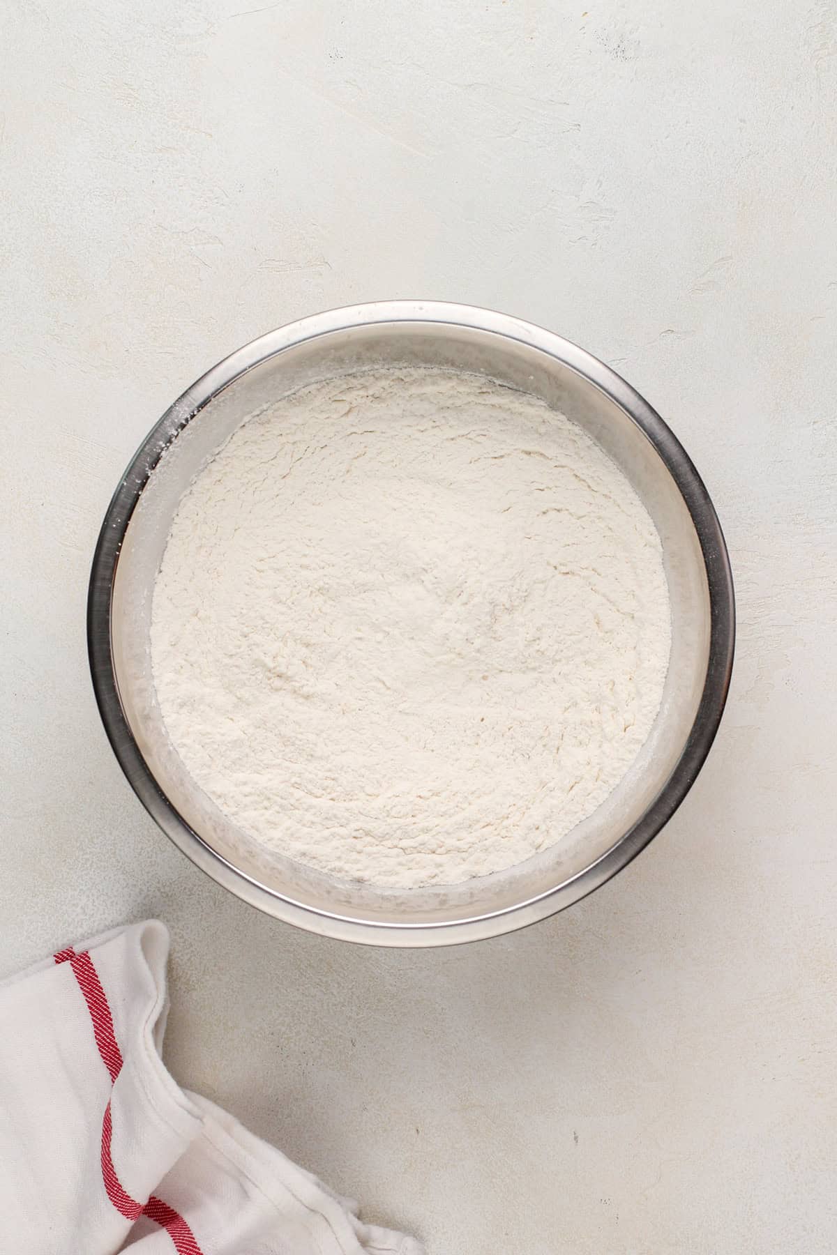 Dry ingredients for salted caramel chocolate chip cookies combined in a metal bowl.