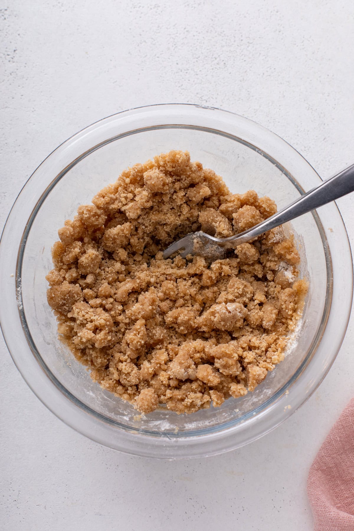 Streusel topping for strawberry rhubarb crumb cake mixed in a glass bowl.