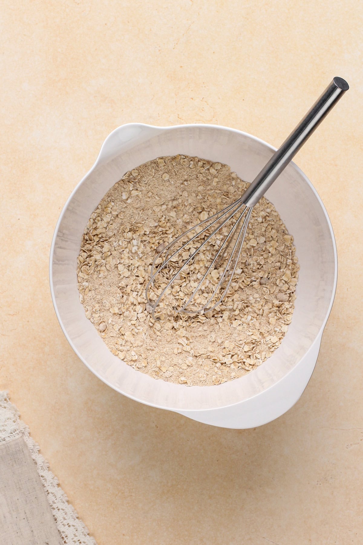 Dry ingredients for peach crisp topping in a white bowl.