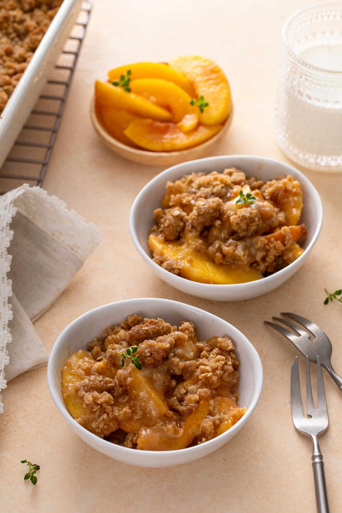 Two white bowls filled with peach crisp.