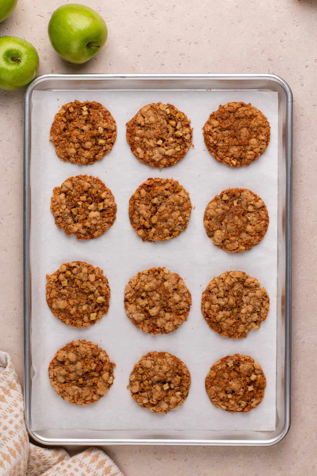 Baked apple spice cookies on a lined baking sheet.