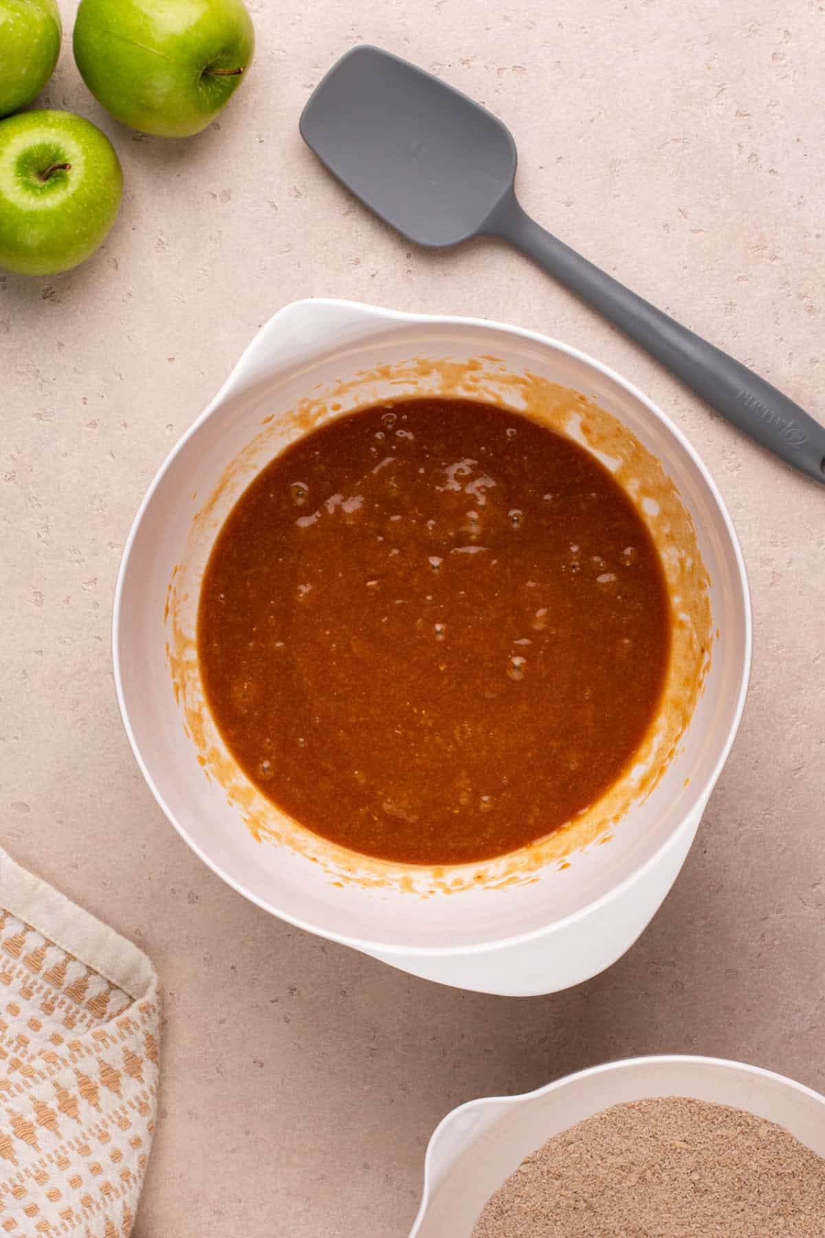 Wet ingredients for apple spice cookies mixed in a white bowl.