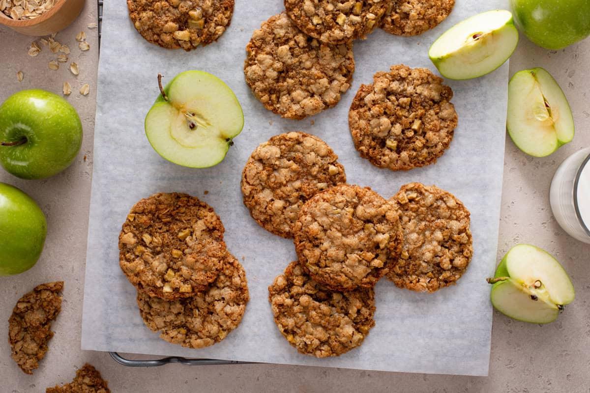 Overhead view of apple spice cookies scattered on a piece of parchment paper.