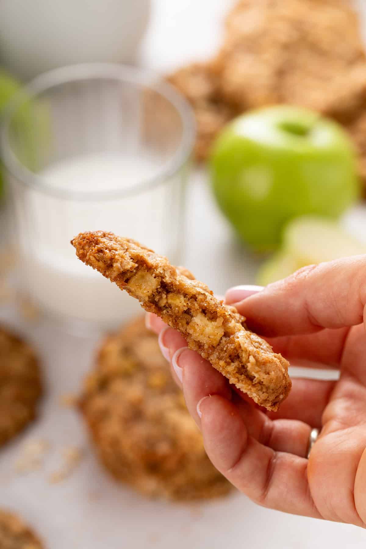 Hand holding up half of an apple spice cookie.