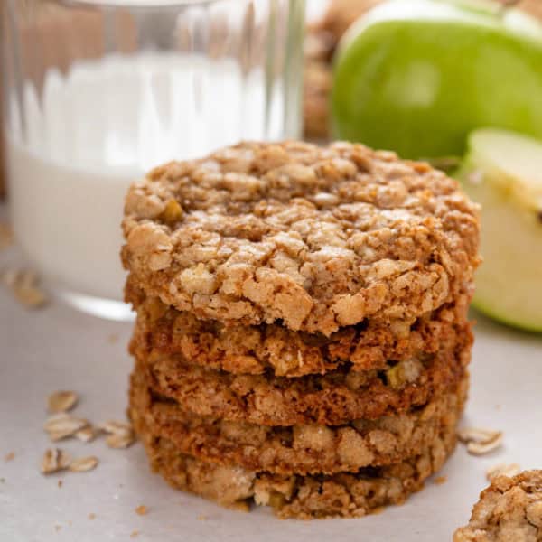 Four apple spice cookies stacked on a countertop.