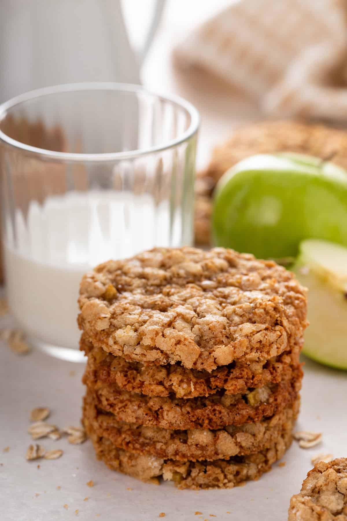 Stack of apple spice cookies in front of a glass of milk.