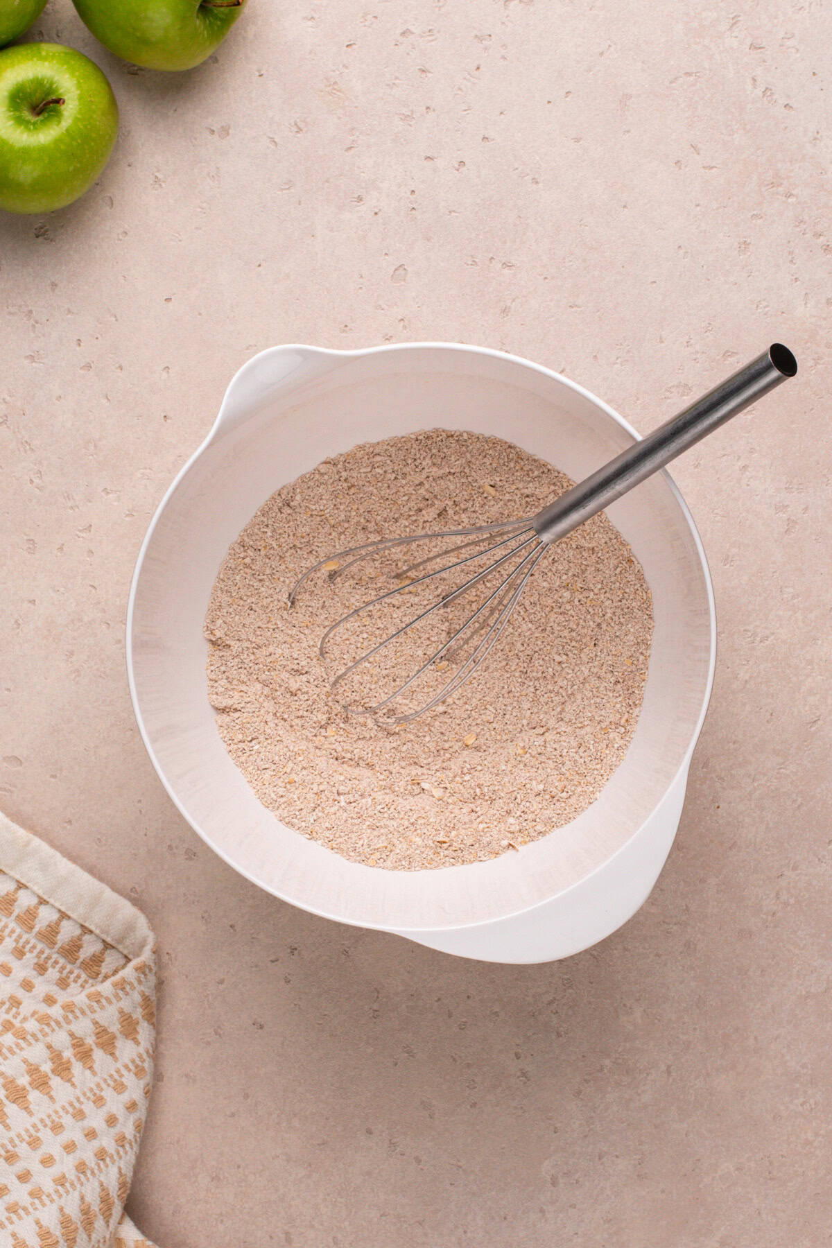 Dry ingredients for apple spice cookies whisked in a white bowl.