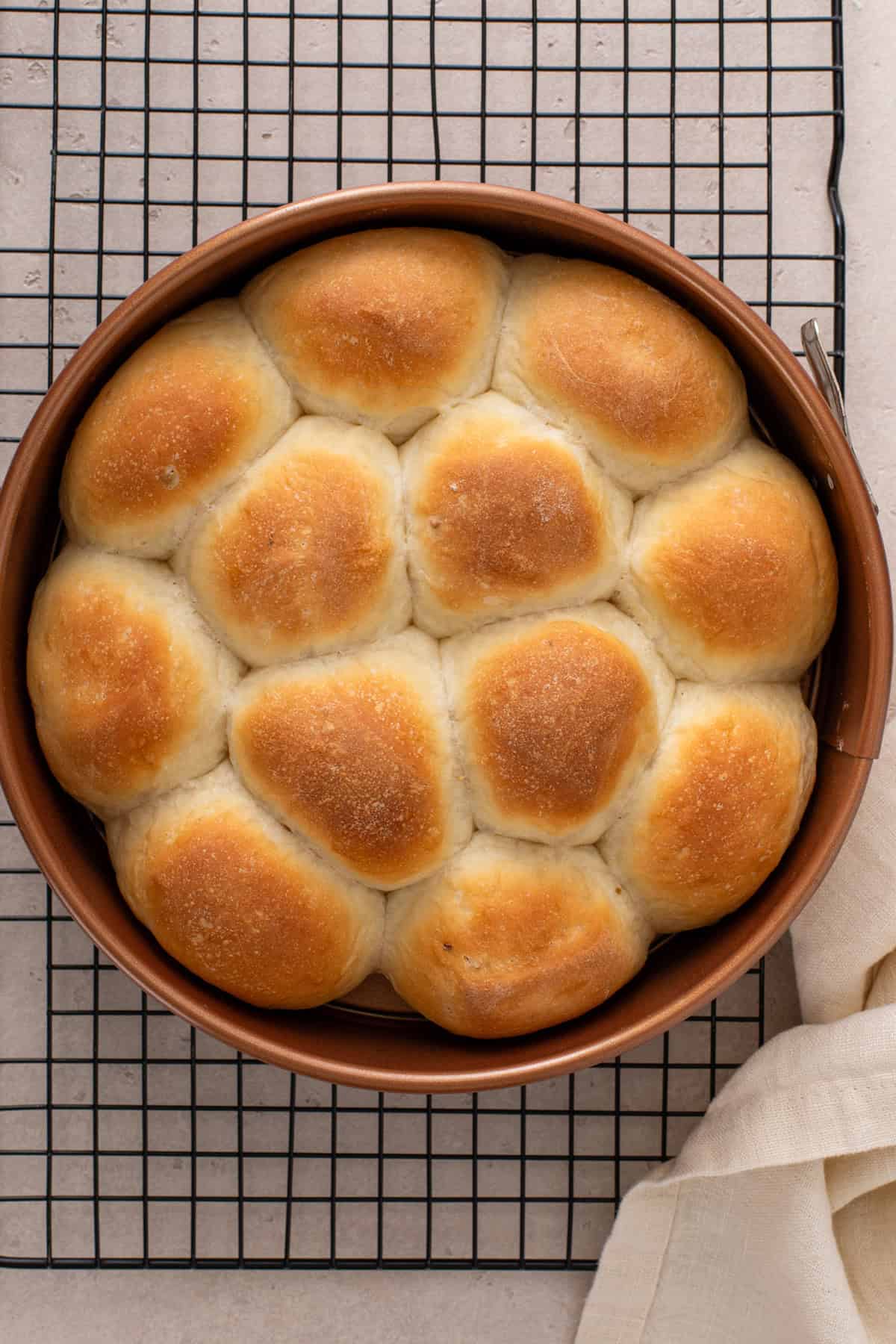 Fully baked brown and serve rolls on a wire rack.
