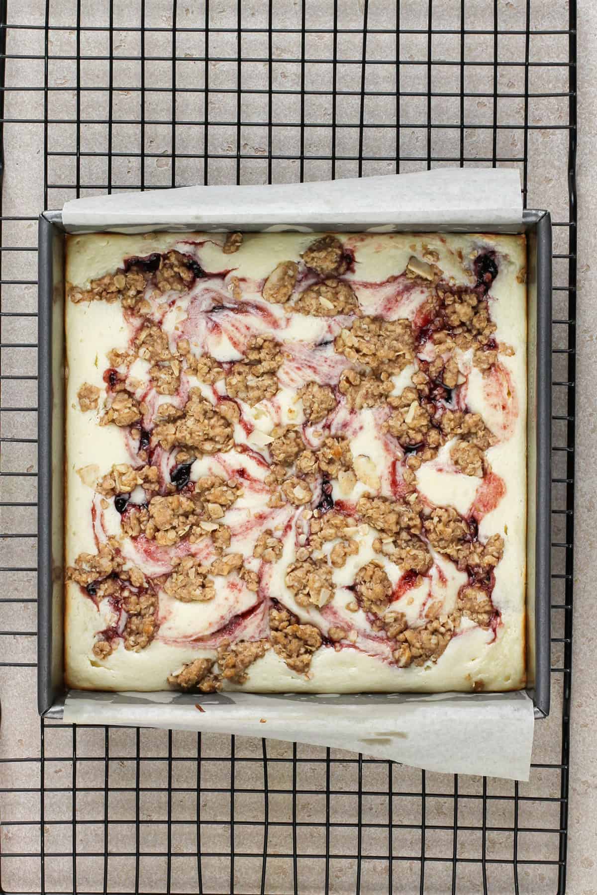 Baked cherry cheesecake bars cooling on a wire rack.