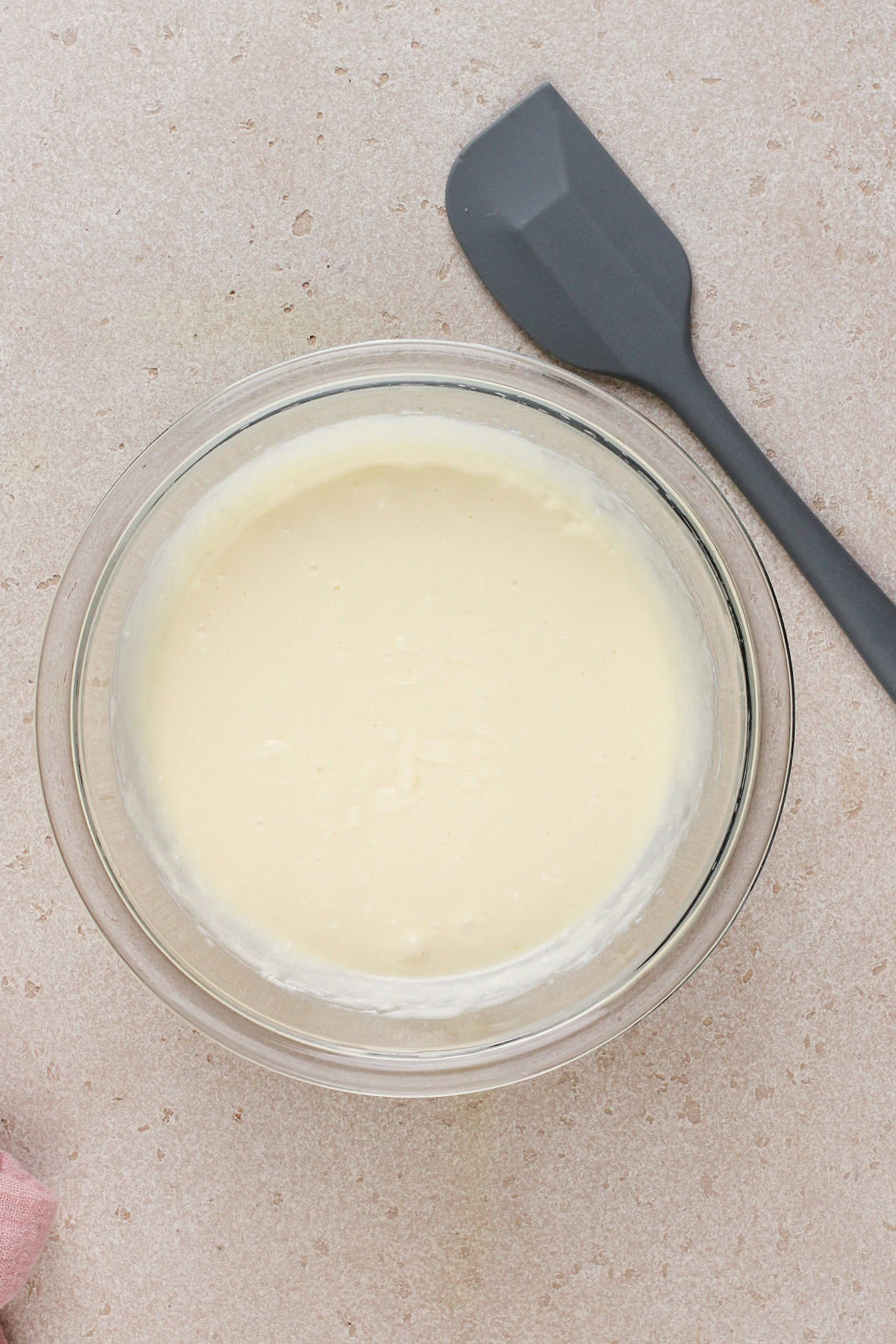 Cheesecake filling batter in a glass bowl.