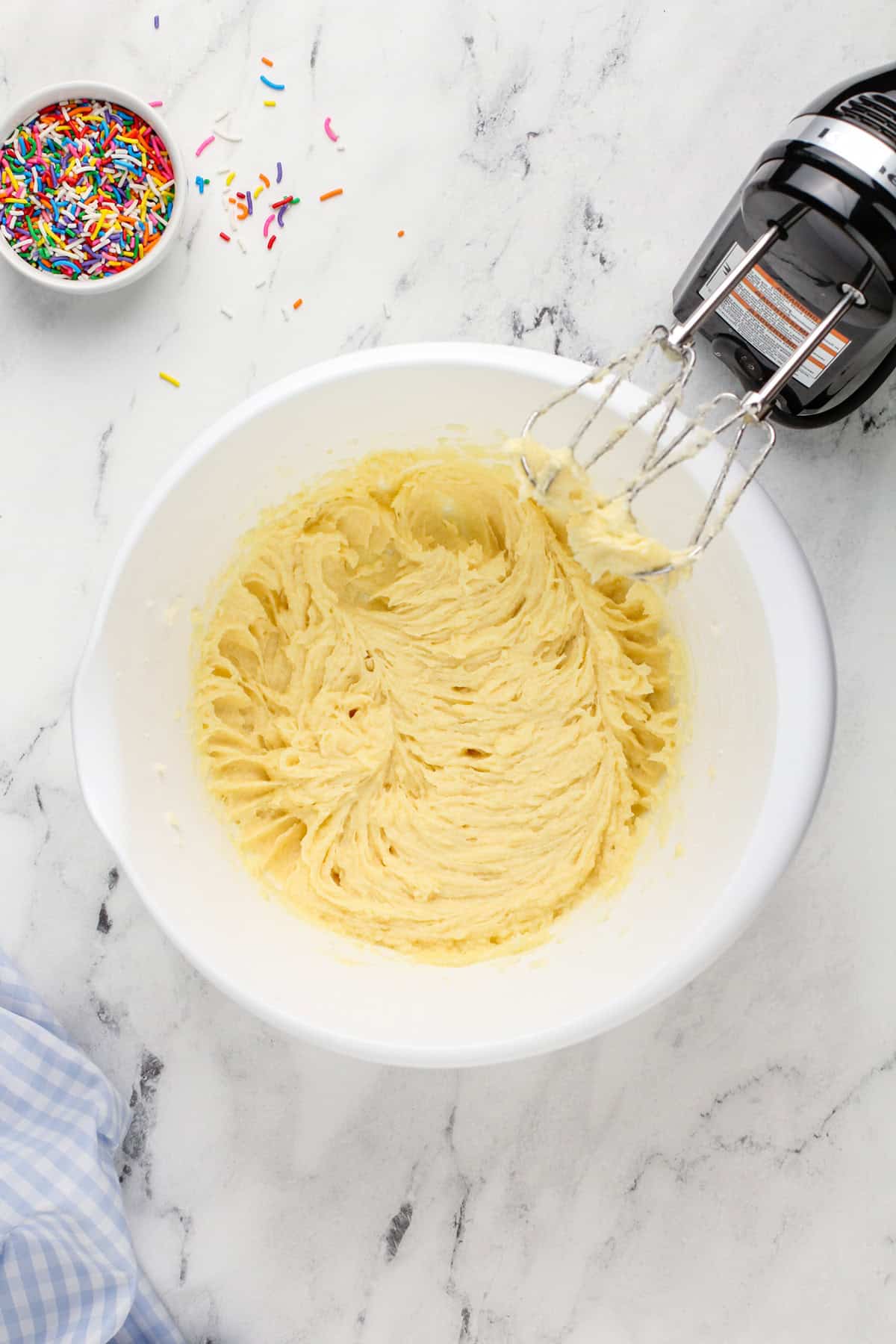 Wet ingredients for birthday cake cookies mixed in a white mixing bowl.