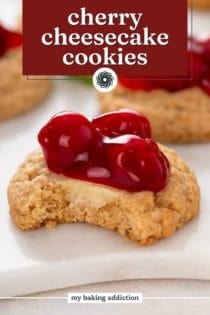 Bite taken from a cherry cheesecake cookie on a marble board. Text overlay includes recipe name.