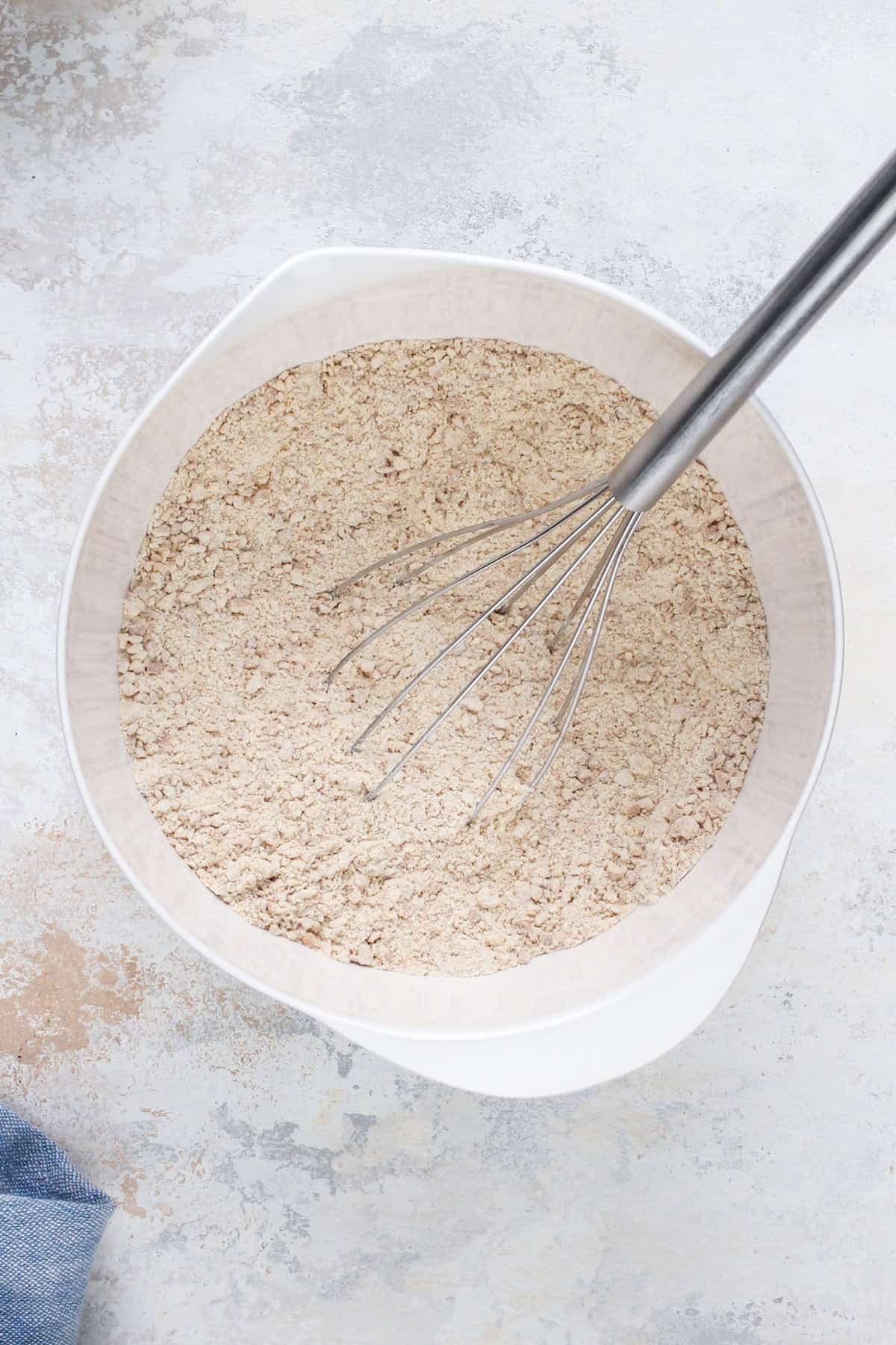 Dry ingredients for cherry cheesecake cookies whisked in a white bowl.