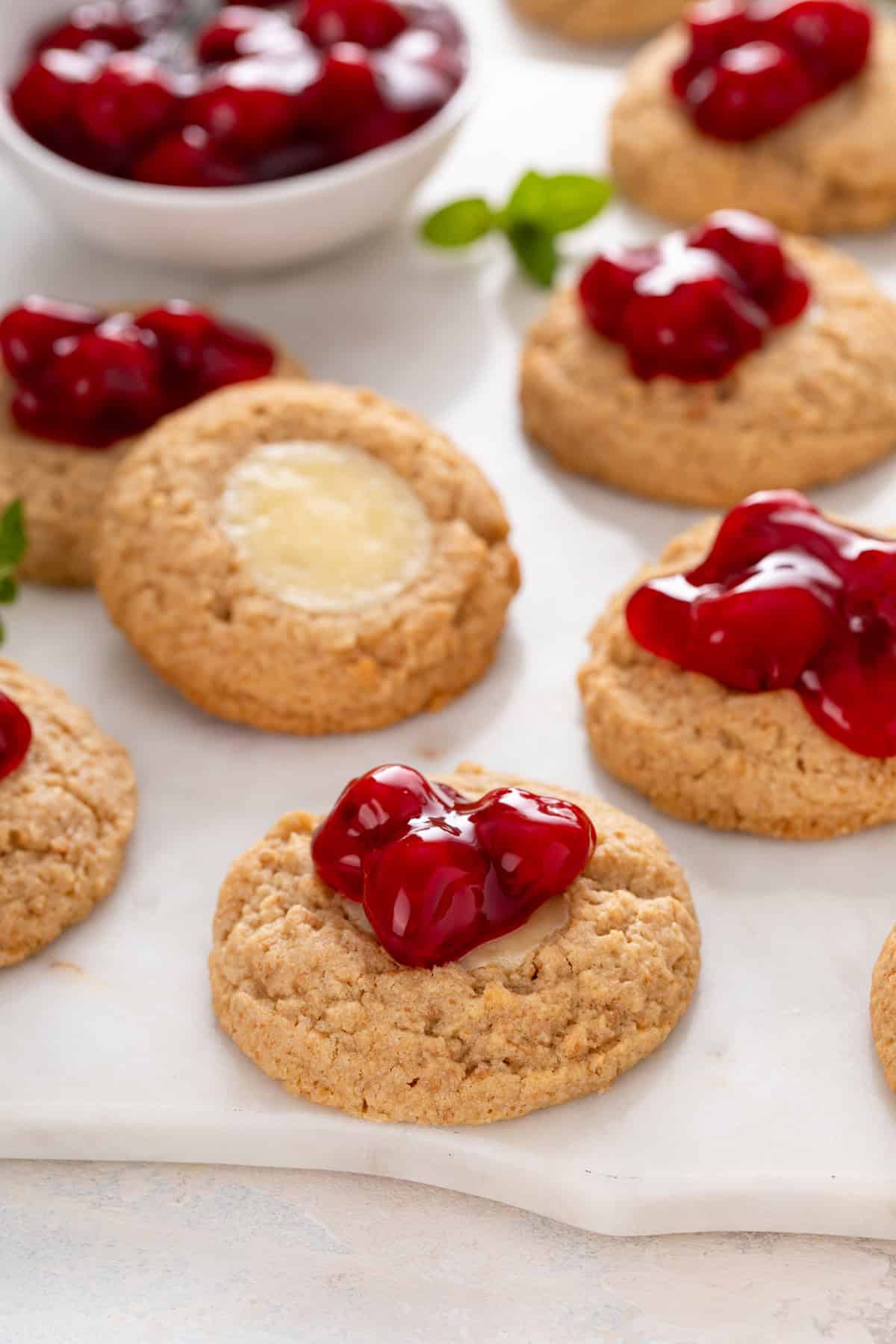 Close up of cherry cheesecake cookies on a marble board.