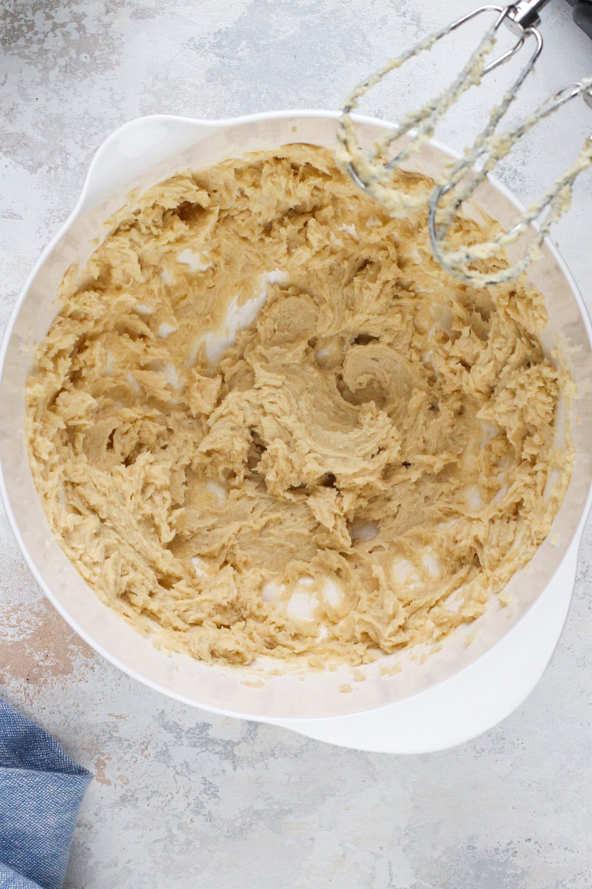 Wet ingredients for cherry cheesecake cookies mixed in a white bowl.