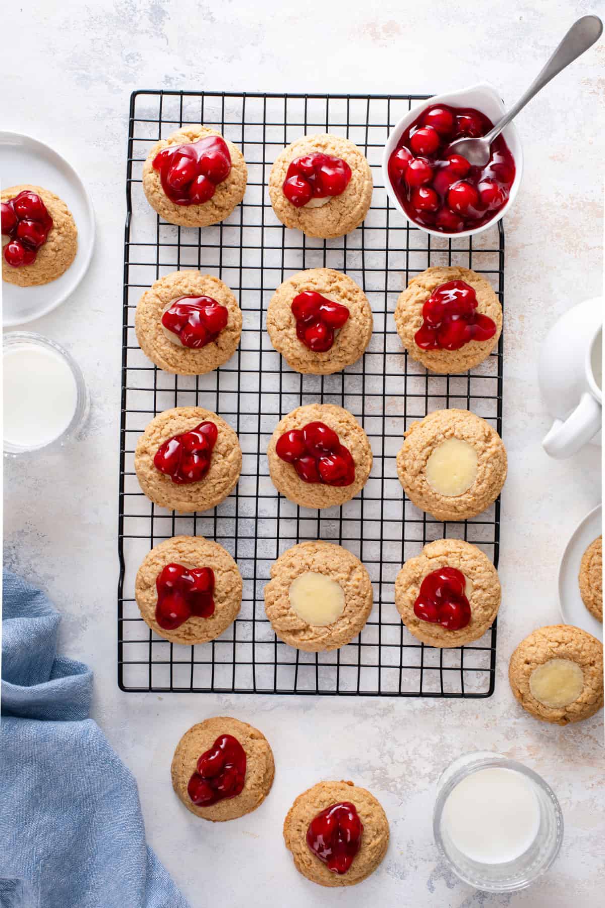 Cherry cheesecake cookies lined up on a wire rack.