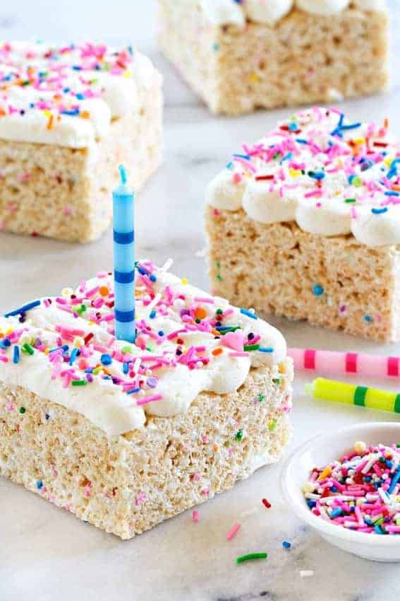 Birthday Marshmallow Cereal Treats are topped with buttercream frosting and loaded with sprinkles.
