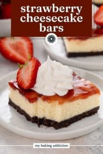 Bite taken from a plated strawberry cheesecake bar topped with whipped cream and a fresh strawberry. Text overlay includes recipe name.