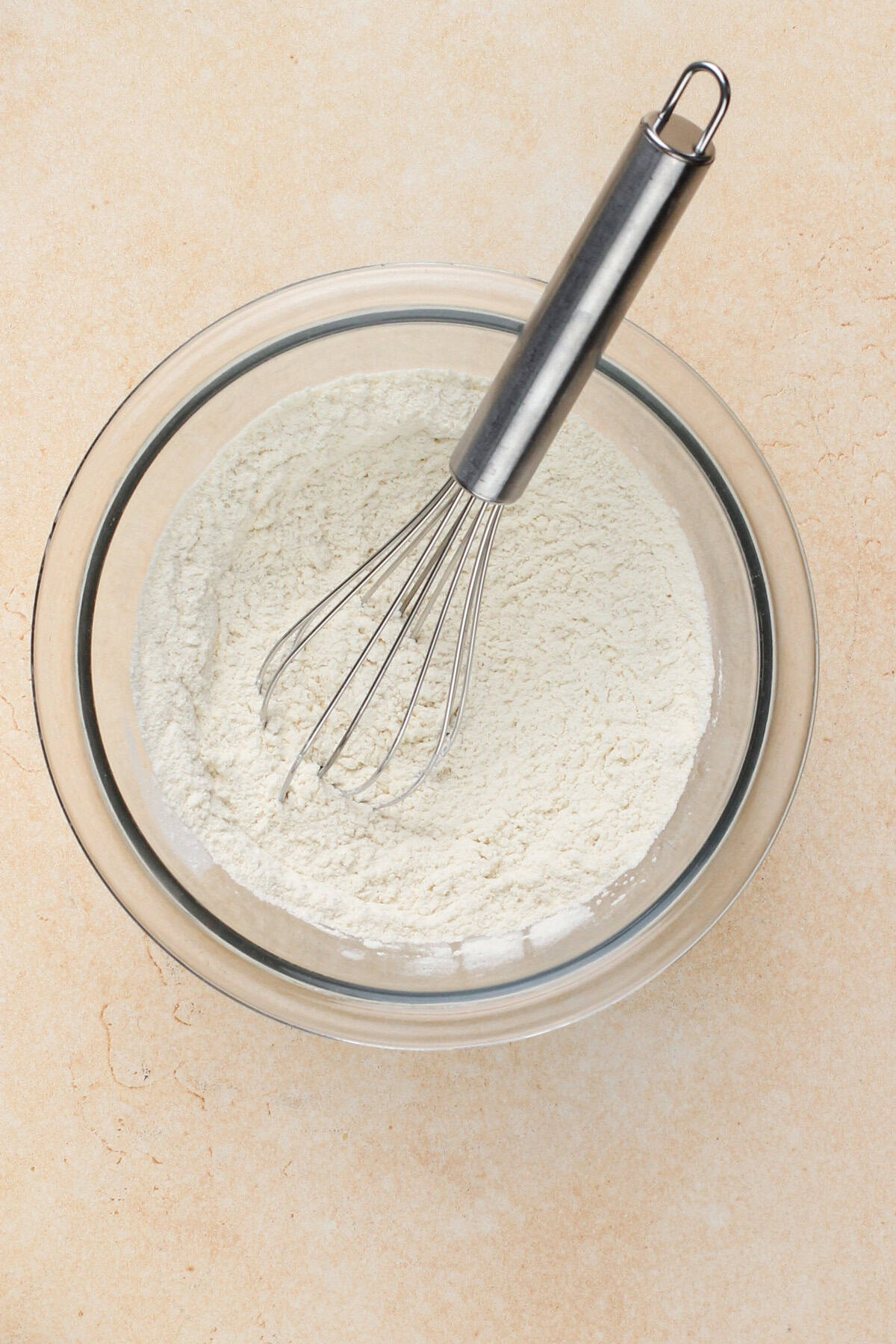 Dry ingredients whisked together in a glass bowl.
