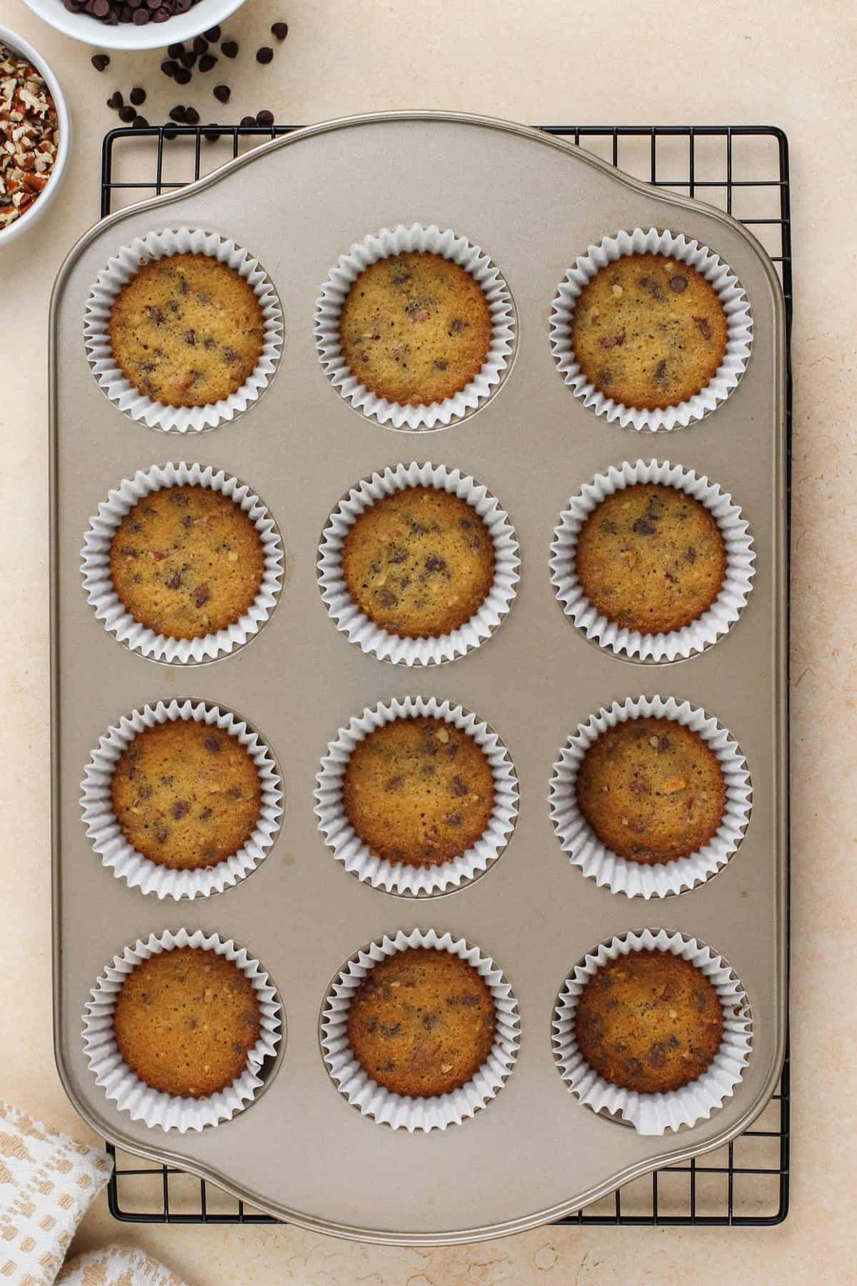 Baked cookie crusts for mini cheesecakes cooling in the pan.