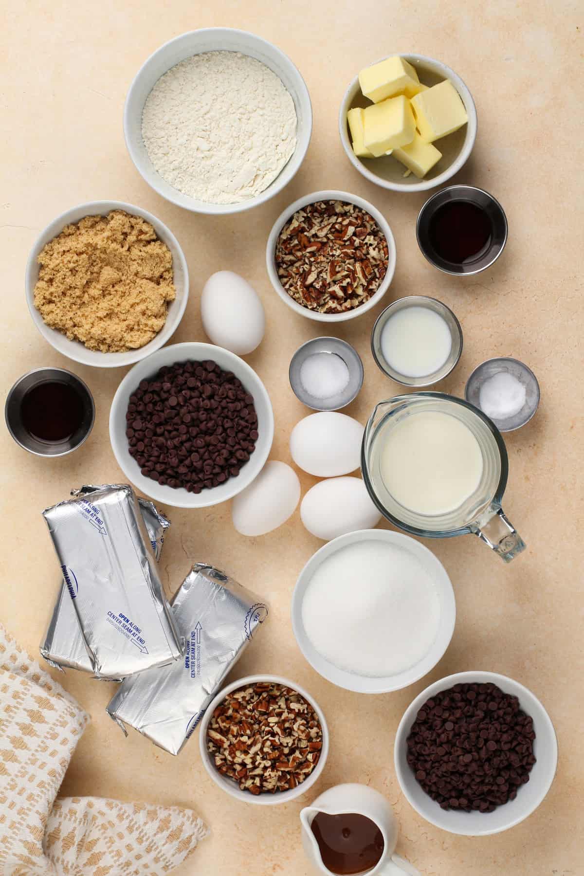 Ingredients for mini turtle cheesecakes arranged on a countertop.