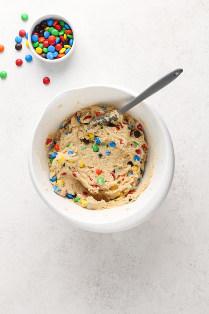 M&M cookie dough in a white mixing bowl.