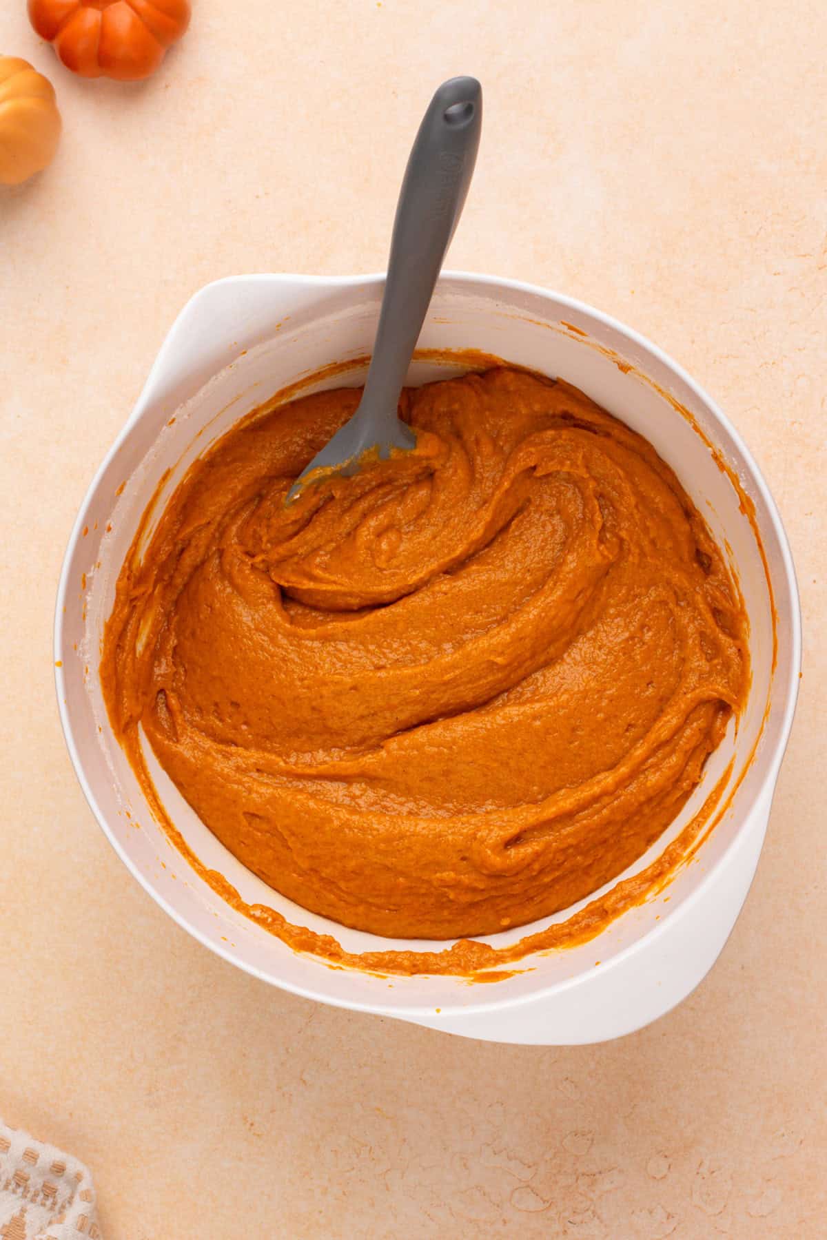 Batter for pumpkin cookies mixed in a white bowl.