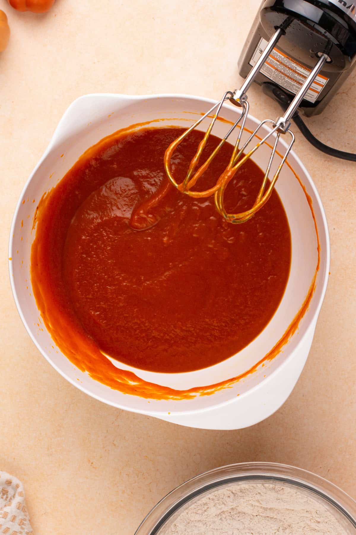 Wet ingredients for pumpkin whoopie pies mixed in a white bowl.