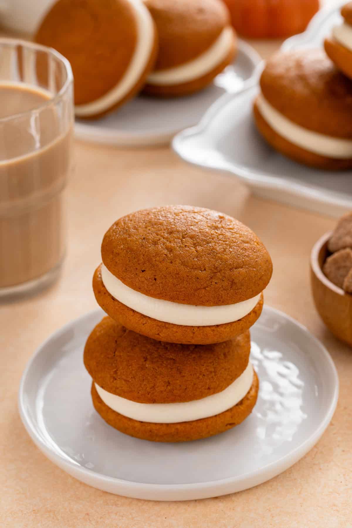Two pumpkin whoopie pies stacked on a gray plate.