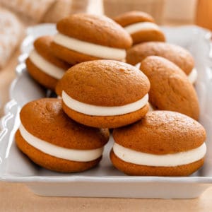 Pumpkin whoopie pies stacked on a platter.