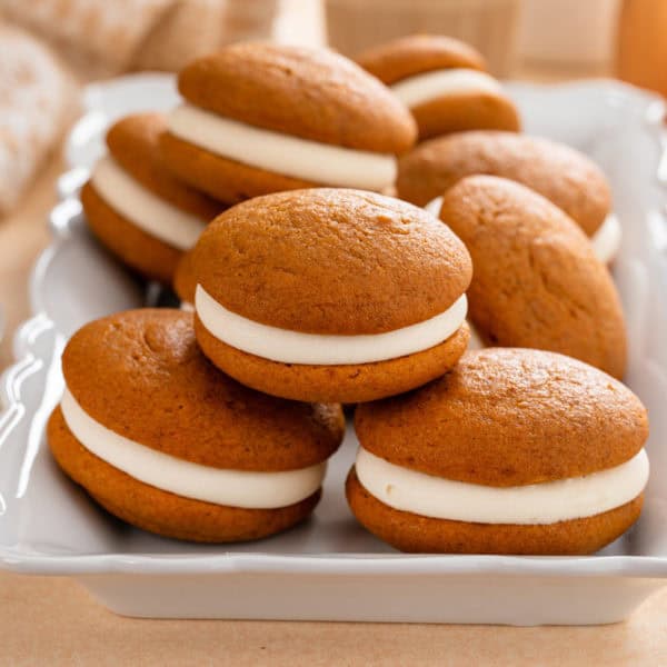 Pumpkin whoopie pies stacked on a platter.
