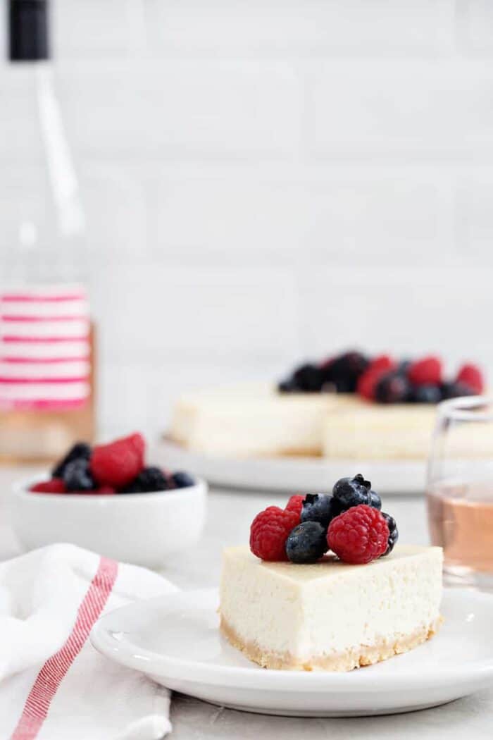Rosé Cheesecake is smooth, creamy, and full of delicious flavors. A sugar cookie crust and rosé soaked berries make it totally irresistible.