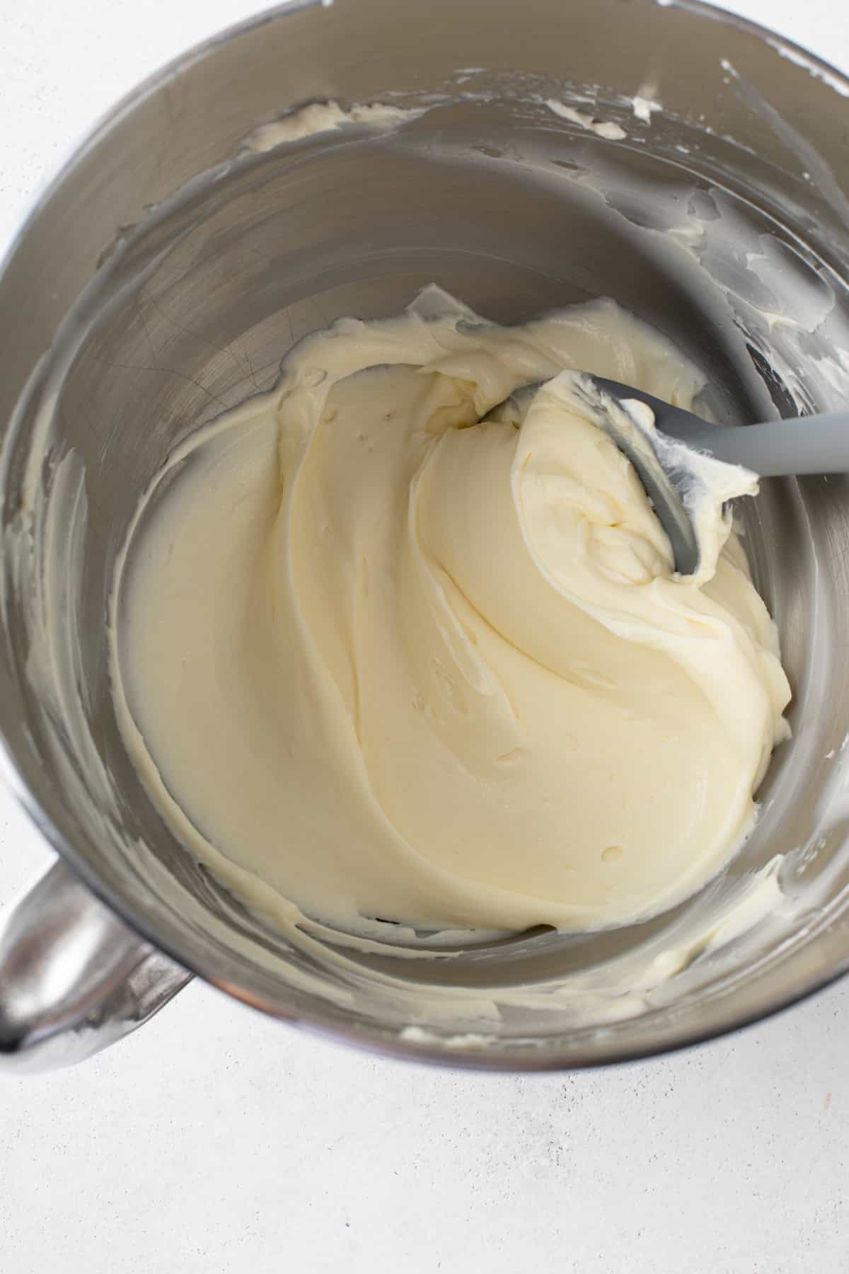 Cream cheese beaten with powdered sugar and vanilla in the bowl of a mixer.
