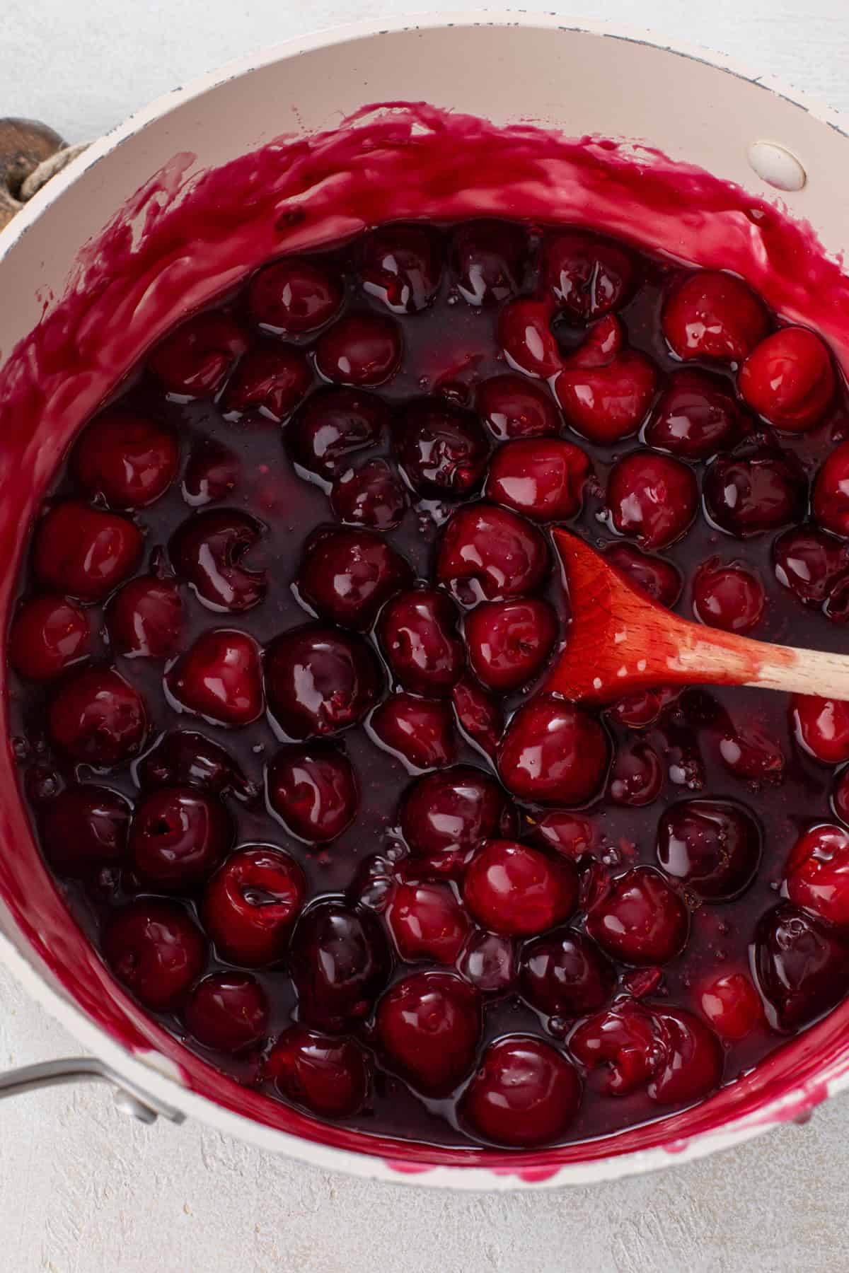 Thickened cherry pie filling in a sauce pot.
